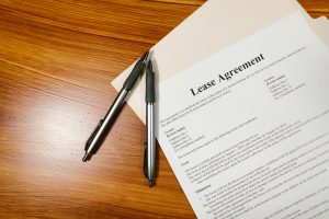 pexels photo 7841414 7841414 High-angle view of a lease agreement and pens on a wooden desk.